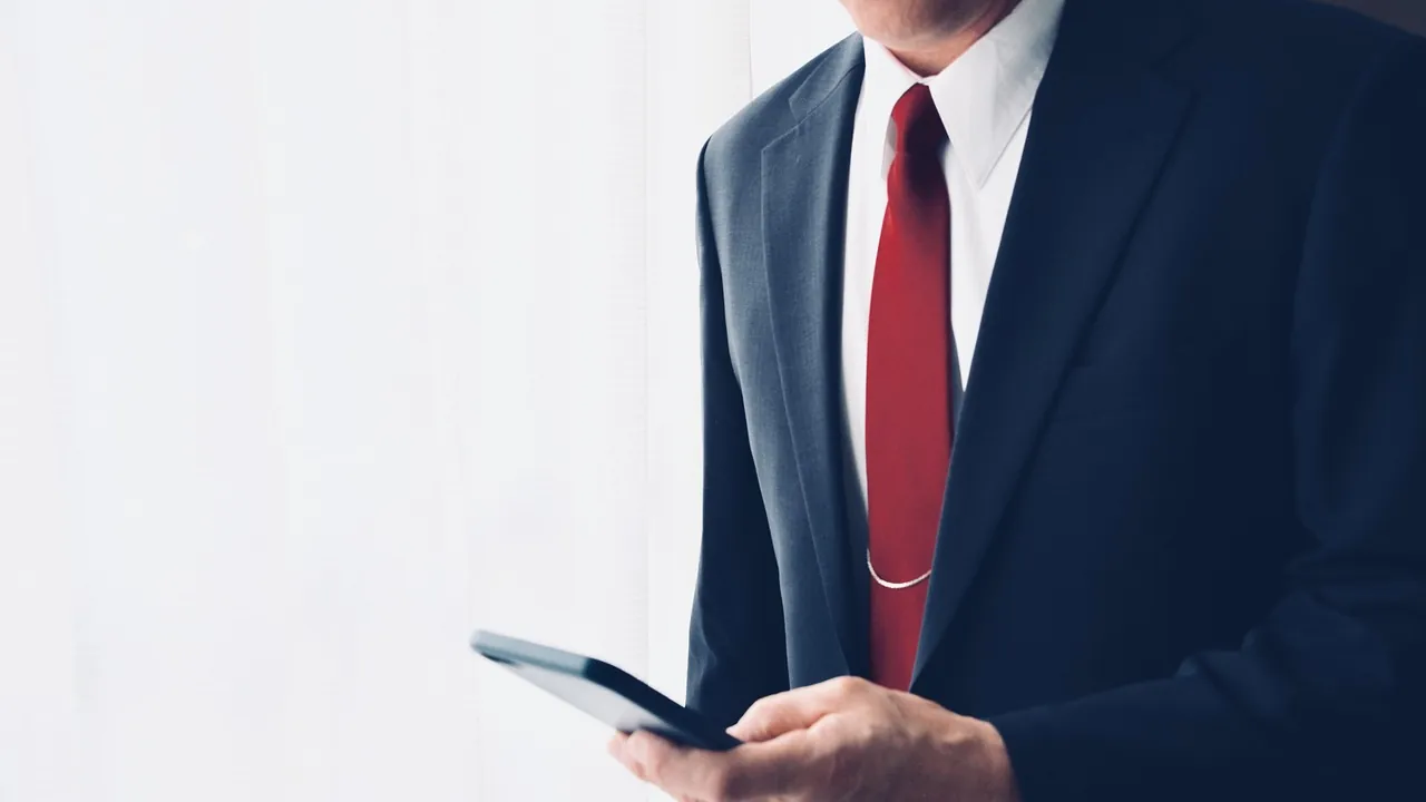 Dirigeant en costume consultant son téléphone