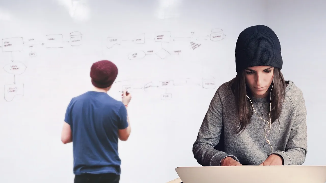Deux collègues au travail, l'un devant un tableau blanc, l'autre sur son ordinateur