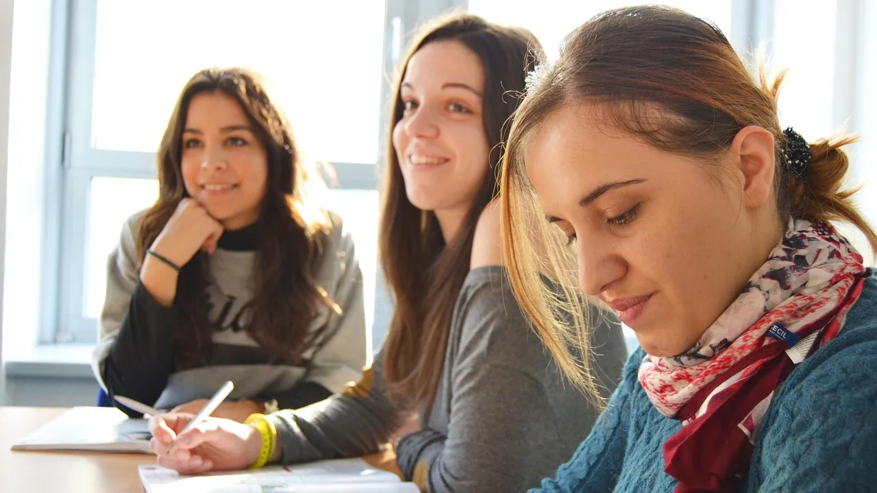 Trois jeunes femmes souriantes travaillant ensemble à une table
