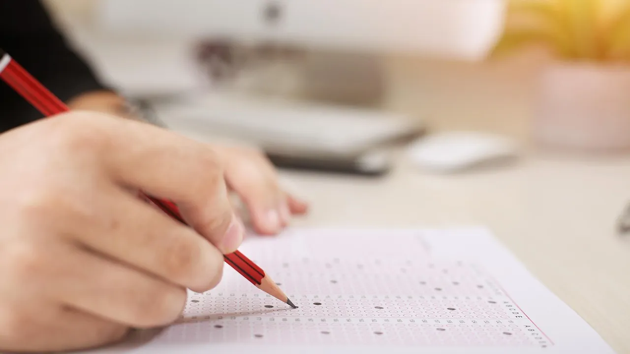Main tenant un stylo rouge au-dessus d'un questionnaire à cocher
